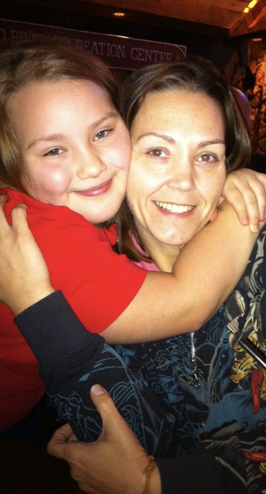 Young Marissa hugging a family member